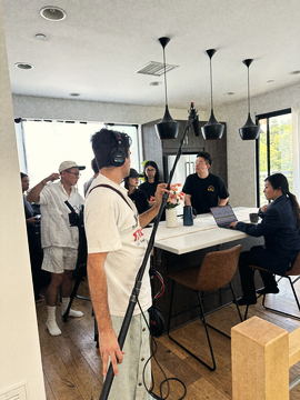 Boom operator and crew around the table scene