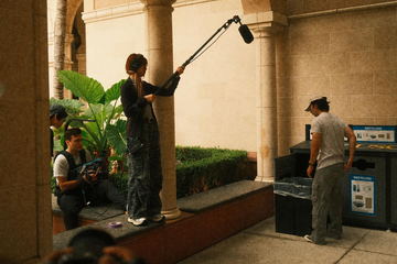 The boom operator beside a colonnade in warm evening light