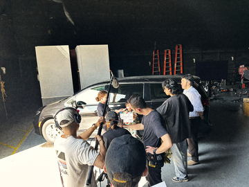 Crew gathered at the car on the soundstage as the slate goes in