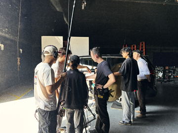 Boom operator and crew beside the picture car