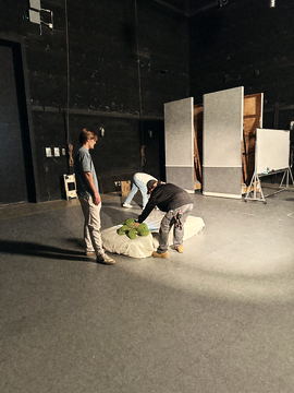 Setting the bedding prop on the empty stage floor