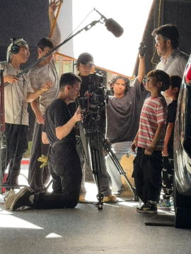 Crew gathered around the camera beside the picture car