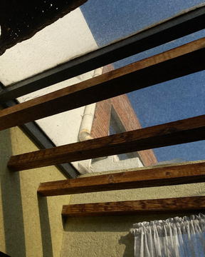 Timber beams crossing a bright skylight
