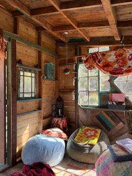 A wooden cabin interior with beanbags and a window seat