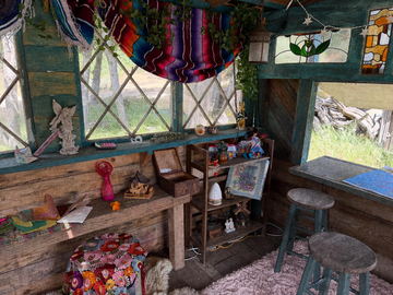 A cabin interior dressed with bunting, ceramics and a workbench